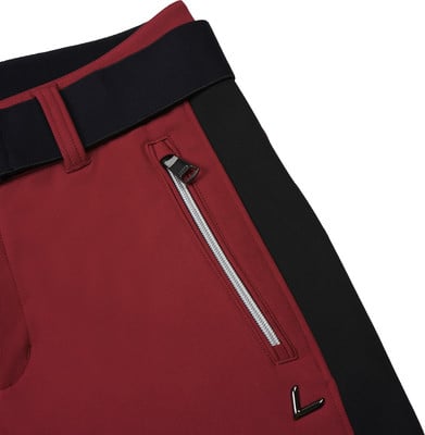 Detail einer Hose mit schwarzem Streifen und Reißverschlusstasche auf burgunderrotem Stoff. Detail einer Hose mit schwarzem Streifen und Reißverschlusstasche auf burgunderrotem Stoff.