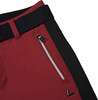 Detail einer Hose mit schwarzem Streifen und Reißverschlusstasche auf burgunderrotem Stoff.
