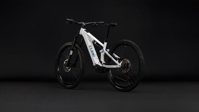 Ein weißes vollgefedertes Cube E-Bike mit schwarzen Rädern vor dunklem Hintergrund.