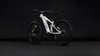 Ein weißes vollgefedertes Cube E-Bike mit schwarzen Rädern vor dunklem Hintergrund.