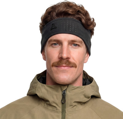Ein Mann mit Schnurrbart trägt ein dunkles Stirnband und eine Khaki-Jacke. Ein Mann mit Schnurrbart trägt ein dunkles Stirnband und eine Khaki-Jacke.