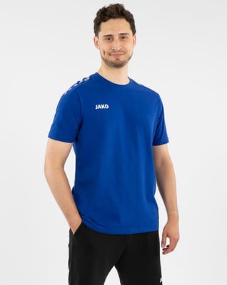 Ein Mann in einem blauen T-Shirt und schwarzen Trainingshosen steht mit der Hand in der Tasche. Ein Mann in einem blauen T-Shirt und schwarzen Trainingshosen steht mit der Hand in der Tasche.