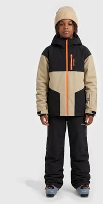 Junge in einer beigefarbenen Skijacke mit orangefarbenem Reißverschluss und schwarzer Hose. Junge in einer beigefarbenen Skijacke mit orangefarbenem Reißverschluss und schwarzer Hose.