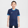 Junge in dunkelblauem Nike-Shirt mit blauem Kragen und Ärmelbund.
