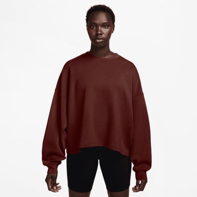 Eine Frau in einem dunkelroten Pullover und schwarzen Shorts steht vor weißem Hintergrund. Eine Frau in einem dunkelroten Pullover und schwarzen Shorts steht vor weißem Hintergrund.