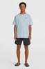 Ein Mann in einem blauen T-Shirt und schwarzen Shorts steht vor einem weißen Hintergrund.