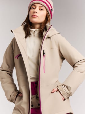 Frau in beiger Jacke und gestreifter Mütze mit rosa Details.