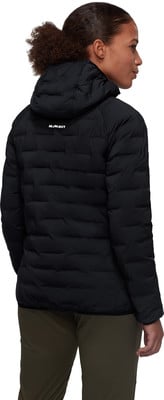 Rückansicht einer Frau in schwarzer Daunenjacke und Khaki-Hose.