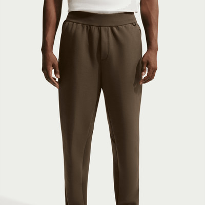 Mann in brauner Hose mit weißem Oberteil, Taillendetail.