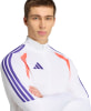 Mann in weißer Adidas Jacke mit lila Streifen und orangefarbenen Details.