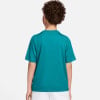 Rückansicht eines Jungen im türkisfarbenen T-Shirt und weißer Hose.