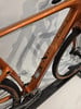 Orange Fahrradrahmen mit Kette und Radfelge.