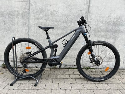 Graues E-Bike von Conway mit Ständer vor Betonwand. Graues E-Bike von Conway mit Ständer vor Betonwand.
