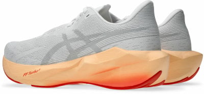 Weiße Laufschuhe mit orange-rotem Sohlenverlauf. Weiße Laufschuhe mit orange-rotem Sohlenverlauf.