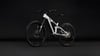 Ein weißes E-Bike mit Federung vor schwarzem Hintergrund.