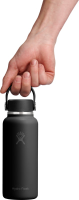 Eine Hand hält eine schwarze Hydro Flask Flasche am Henkel. Eine Hand hält eine schwarze Hydro Flask Flasche am Henkel.