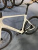 Ein weißes Cube Rennrad mit schwarzen Rädern und Sattel auf blauem Teppich.