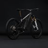 Schwarzes E-Mountainbike mit Federung und goldenen Akzenten auf schwarzem Hintergrund.