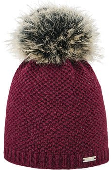 Eine bordeauxrote Strickmütze mit Bommel aus Kunstfell und einem Metallanhänger.