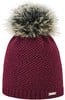 Eine bordeauxrote Strickmütze mit Bommel aus Kunstfell und einem Metallanhänger.