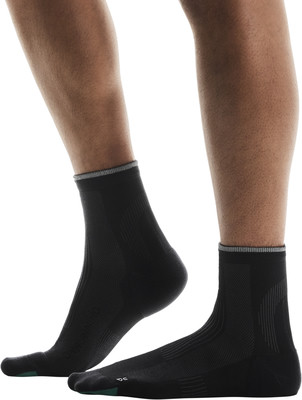 Blick auf Füße in schwarzen Socken mit grauem Bund und grüner Spitze. Blick auf Füße in schwarzen Socken mit grauem Bund und grüner Spitze.