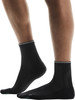 Blick auf Füße in schwarzen Socken mit grauem Bund und grüner Spitze.