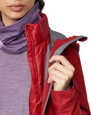 Detail einer Damen-Rotjacke mit lila Schal und Reißverschluss. Detail einer Damen-Rotjacke mit lila Schal und Reißverschluss.