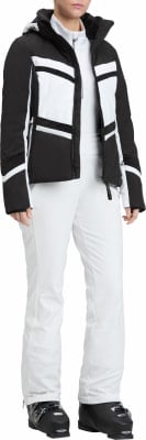 Frau in einer stilvollen schwarz-weißen Skijacke und weißer Hose.