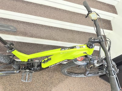 Ein grünes E-Bike mit Digitalanzeige am Lenker steht auf einer Treppe. Ein grünes E-Bike mit Digitalanzeige am Lenker steht auf einer Treppe.
