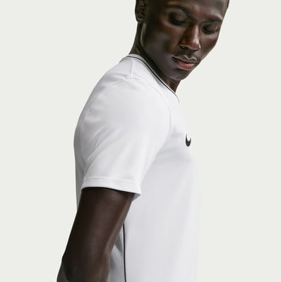 Ein Mann in einem weißen Nike-T-Shirt mit schwarzem Logo und Streifen am Kragen. Ein Mann in einem weißen Nike-T-Shirt mit schwarzem Logo und Streifen am Kragen.