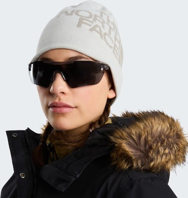 Frau im Wintermantel mit Pelz und Mütze mit The North Face Logo. Frau im Wintermantel mit Pelz und Mütze mit The North Face Logo.