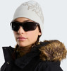 Frau im Wintermantel mit Pelz und Mütze mit The North Face Logo.