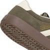 Detail der Sohle und Seite eines grünen Adidas-Sneakers mit cremefarbenen Akzenten.