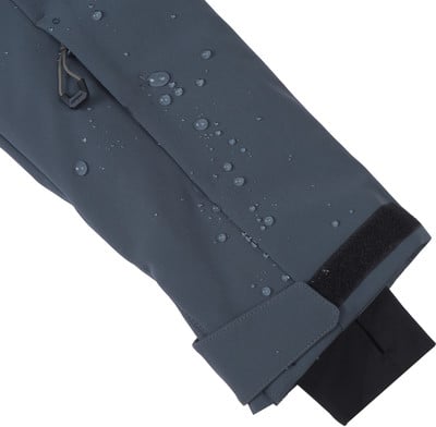 Detail eines dunkelblauen Jackenärmels mit Wassertropfen und Klettverschluss. Detail eines dunkelblauen Jackenärmels mit Wassertropfen und Klettverschluss.