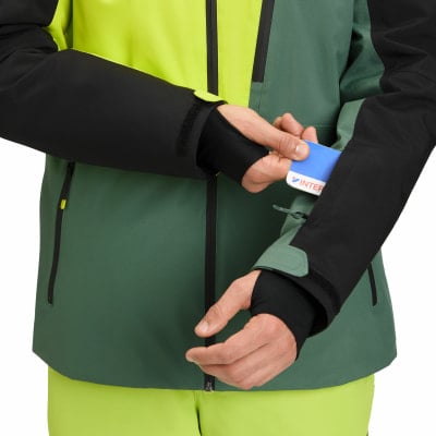 Ein Mann steckt eine Karte in eine Ärmeltasche einer Skijacke. Ein Mann steckt eine Karte in eine Ärmeltasche einer Skijacke.