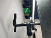 Detail eines Fahrradlenkers mit schwarzem Lenkerband und Bremshebeln.