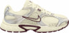 Beige Nike Laufschuh mit silbernen und weinroten Akzenten und Mesh.