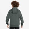 Rückansicht eines Jungen in einem dunkelgrünen Kapuzenpullover mit lockigen Haaren.
