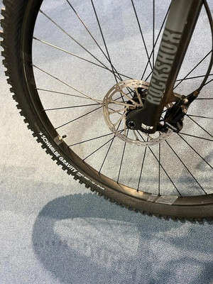 Detail eines Mountainbike-Rads mit Bremsscheibe und RockShox-Aufschrift. Detail eines Mountainbike-Rads mit Bremsscheibe und RockShox-Aufschrift.