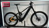 Schwarzes E-Mountainbike mit Federung und gelben Details im Ständer.