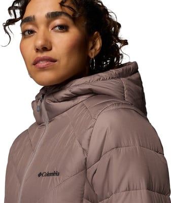 Frau in einer rosa Kapuzenjacke mit Columbia-Logo auf der Brust. Frau in einer rosa Kapuzenjacke mit Columbia-Logo auf der Brust.