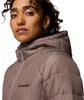 Frau in einer rosa Kapuzenjacke mit Columbia-Logo auf der Brust.