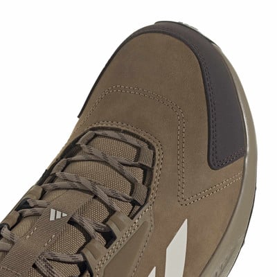 Detail špičky hnědé trekové boty s tkaničkami a logem Adidas. Detail špičky hnědé trekové boty s tkaničkami a logem Adidas.