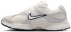Fehér Nike cipő szürke és bézs részletekkel és fekete logóval.