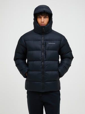 Ein Mann in einer dunkelblauen Daunenjacke mit Stehkragen und Kapuze.