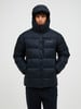 Ein Mann in einer dunkelblauen Daunenjacke mit Stehkragen und Kapuze.