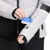 Eine Frau steckt eine Karte in eine Ärmeltasche ihrer Skijacke.