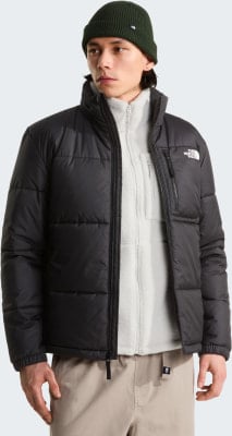Mann in grüner Mütze und schwarzer Daunenjacke mit beige Hose. Mann in grüner Mütze und schwarzer Daunenjacke mit beige Hose.