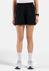 Eine Frau in schwarzen Shorts, weißem T-Shirt und Turnschuhen vor weißem Hintergrund.