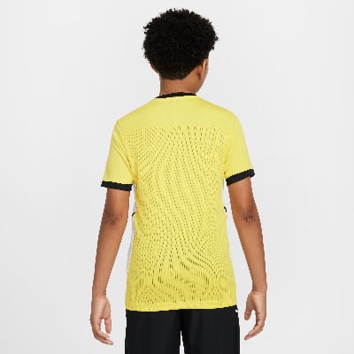 Rückansicht eines Jungen in einem gelben kurzärmeligen T-Shirt mit schwarzen Akzenten. Rückansicht eines Jungen in einem gelben kurzärmeligen T-Shirt mit schwarzen Akzenten.